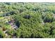 Aerial view showcasing a home surrounded by a vibrant, dense forest and other residential homes nearby at 1252 Grist Mill Dr, Acworth, GA 30101