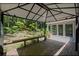 Back deck featuring wooden floorboards, covered pergola, and wooded views at 1252 Grist Mill Dr, Acworth, GA 30101