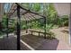 Back deck featuring wooden floorboards, covered pergola, and wooded views at 1252 Grist Mill Dr, Acworth, GA 30101