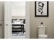 Bathroom view through doorway with toilet, art, and stylish bedroom furnishings at 516 Almere Dr, Hampton, GA 30228