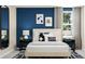 Chic bedroom with navy accent wall, modern art, and stylish bedside lamps create a relaxing space at 516 Almere Dr, Hampton, GA 30228