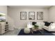 Inviting living room area featuring a modern sofa, stylish ottomans, and contemporary decor at 516 Almere Dr, Hampton, GA 30228
