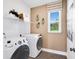 Bright laundry room featuring a front-load washer and dryer, window, and built in shelving at 619 Catesby Ter, Dacula, GA 30019
