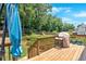 Wooden deck with a grill, seating, and a view of the fenced backyard, perfect for outdoor entertaining at 6236 Millstone Trl, Douglasville, GA 30135