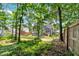 Private backyard with mature trees, a lush lawn, and partial view of the house, creating a serene setting at 6236 Millstone Trl, Douglasville, GA 30135