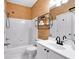 White bathroom with a shower/tub combo, a single vanity, and interesting wallpaper at 6236 Millstone Trl, Douglasville, GA 30135