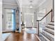Bright foyer featuring hardwood floors, staircase, and a glass-paned front door at 6236 Millstone Trl, Douglasville, GA 30135