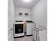 Laundry room with modern washer and dryer and storage shelves at 6236 Millstone Trl, Douglasville, GA 30135