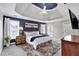 Spacious main bedroom featuring dark blue accent wall, tray ceiling, with attached bathroom and deck access at 6236 Millstone Trl, Douglasville, GA 30135