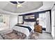 Spacious main bedroom featuring dark blue accent wall, tray ceiling, and attached bathroom with a soaking tub at 6236 Millstone Trl, Douglasville, GA 30135