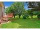 A sprawling backyard is showcased with lush green grass and scattered trees and greenery at 1030 Carriage Trace Cir, Stone Mountain, GA 30087