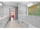 Bathroom with a large soaking tub, window, and double sinks at 1030 Carriage Trace Cir, Stone Mountain, GA 30087