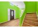 Bright foyer features a wood floor, a staircase, and lime green walls at 1030 Carriage Trace Cir, Stone Mountain, GA 30087