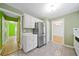 Kitchen with stainless steel refrigerator, white cabinetry, and view into adjacent rooms at 1030 Carriage Trace Cir, Stone Mountain, GA 30087