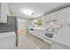 Bright kitchen featuring white appliances and cabinetry, complemented by tiled flooring and a window view at 1030 Carriage Trace Cir, Stone Mountain, GA 30087