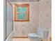 Bathroom with shower, toilet, and window, featuring floral wallpaper and neutral flooring at 2071 Habersham Cir, Covington, GA 30014