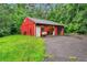 Red two car garage with an adjacent lawn in a verdant, wooded area and a large driveway at 2071 Habersham Cir, Covington, GA 30014