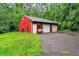 Red two car garage with an adjacent lawn in a verdant, wooded area and a large driveway at 2071 Habersham Cir, Covington, GA 30014