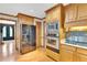 Well-lit kitchen with stainless appliances, wood cabinetry, and hardwood floors at 2071 Habersham Cir, Covington, GA 30014