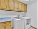 Laundry room with modern washer and dryer, cabinet space, and neutral colored cabinets at 2071 Habersham Cir, Covington, GA 30014