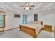 Spacious main bedroom with a decorative tray ceiling and carpet flooring at 2071 Habersham Cir, Covington, GA 30014