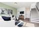 Spacious living room featuring a staircase, modern sofa, and recessed lighting at 2682 Brookview Nw Ln, Atlanta, GA 30318