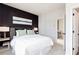 Inviting main bedroom featuring a dark accent wall, plush carpet, and modern lighting at 2682 Brookview Nw Ln, Atlanta, GA 30318