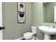 Stylish powder room with a pedestal sink, modern fixtures, and contemporary artwork at 2682 Brookview Nw Ln, Atlanta, GA 30318
