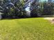 Large, grassy backyard with a wooden fence and mature trees offering privacy at 5050 Roxton Ln, Douglasville, GA 30135