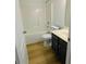 Bathroom featuring a shower-tub combo, dark vanity, and wood-look flooring at 5050 Roxton Ln, Douglasville, GA 30135