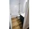 Bathroom featuring a shower-tub combo, dark vanity, and wood-look flooring at 5050 Roxton Ln, Douglasville, GA 30135