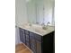 Bathroom vanity with double sinks, dark cabinets, light countertops, and modern faucets at 5050 Roxton Ln, Douglasville, GA 30135