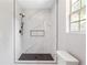 Modern shower with marble tile, dark fixtures, and a glass enclosure offers a luxurious bathing experience at 5484 Denny Dr, Atlanta, GA 30349