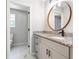 Stylish bathroom with a granite countertop vanity, round mirror, and marble flooring is designed for comfort and elegance at 5484 Denny Dr, Atlanta, GA 30349