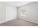 A cozy bedroom with a window view and carpet, complemented by a built-in closet at 5484 Denny Dr, Atlanta, GA 30349