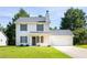 Charming two-story home features a symmetrical design with white siding and black shutters and an attached two-car garage at 5484 Denny Dr, Atlanta, GA 30349