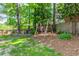 Spacious backyard features mature trees, a charming swing set, and an inviting outdoor seating area with an umbrella at 706 Powder Springs Se St, Smyrna, GA 30080