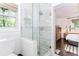 Bathroom showing the shower, white marble-look tile, and access to the stylish primary bedroom at 706 Powder Springs Se St, Smyrna, GA 30080