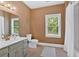 Bathroom features a large mirror and vanity with neutral colors and a bright window view at 14 Black Forest Run, Douglasville, GA 30134