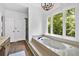 Luxurious bathroom with soaking tub, large window with outdoor view, and elegant finishes at 14 Black Forest Run, Douglasville, GA 30134