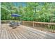 Wooden deck featuring a table, chairs, and umbrella, perfect for outdoor dining and relaxation at 14 Black Forest Run, Douglasville, GA 30134