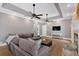 Bright living room with wood floors, fireplace, large sectional, tray ceiling, and modern finishes at 14 Black Forest Run, Douglasville, GA 30134