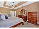 Bright main bedroom with tray ceiling, four poster bed, and adjacent en suite bath at 14 Black Forest Run, Douglasville, GA 30134