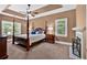Cozy main bedroom features a four poster bed, sitting area, fireplace, and tray ceiling at 14 Black Forest Run, Douglasville, GA 30134
