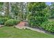 Tranquil backyard with a bridge, lush landscaping, and mature trees, creating a serene and inviting outdoor space at 522 Golfview Dr, Peachtree City, GA 30269