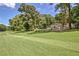 Expansive backyard view with lush lawn, mature trees, and a glimpse of the home, ideal for outdoor activities at 522 Golfview Dr, Peachtree City, GA 30269