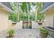 An open gate leads to a secluded front courtyard featuring a fountain and mature shade trees at 522 Golfview Dr, Peachtree City, GA 30269
