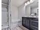 Modern bathroom featuring a shower, bathtub, gray vanity with sink, and a large mirror with sleek lighting at 5512 Cascade Run, Atlanta, GA 30336