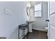 Stylish half-bath features a pedestal sink, decorative mirror, and modern fixtures at 5512 Cascade Run, Atlanta, GA 30336