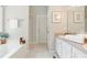 Bright bathroom featuring double vanity, white cabinetry, soaking tub, and decorative wall art at 75 Fox Chase, Covington, GA 30016
